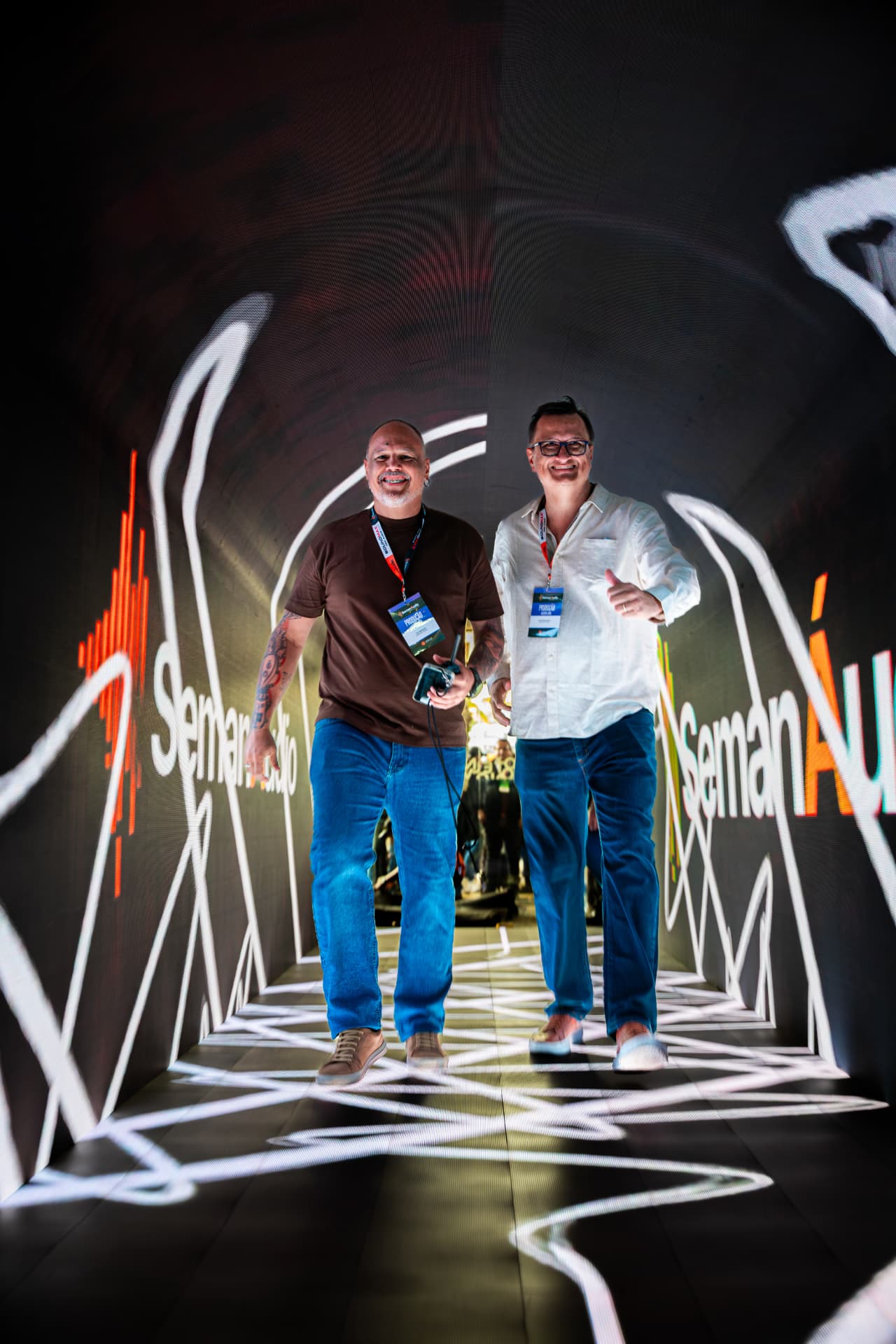 Dois profissionais caminhando pelo túnel de LED da SemanÁudio