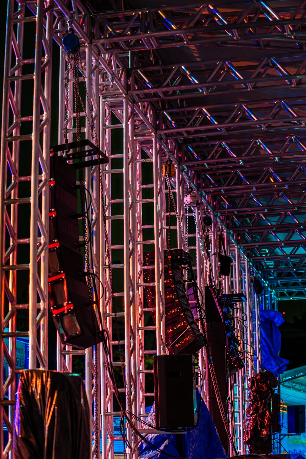 Caixas line array suspensas em estrutura de box truss iluminada